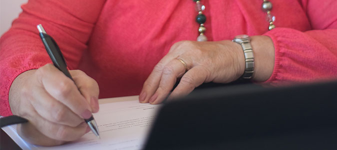 Image of woman signing power of attorney document